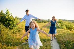 Dad mom and daughter have fun together in nature. photo