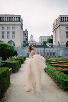 Portrait of a lovely young girl in a lush dress walking around the park and the Grand Palace photo