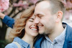 pareja enamorada en un floreciente huerto de manzanas sobre la manta foto