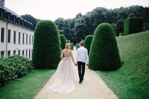 a trendy young couple walks in the city in summer, the young woman wears a luxury dress photo