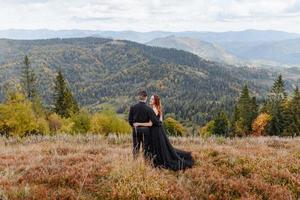 pareja de novios sobre un fondo de montañas de otoño. foto