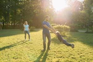 los padres juegan en el parque con su hijo foto