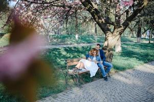 pareja enamorada en un floreciente huerto de manzanas sobre la manta foto