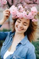 Beautiful woman enjoying daisy field, nice female lying down in meadow of flowers, pretty girl relaxing outdoor, having fun, holding plant, happy young lady and spring green nature, harmony concept photo