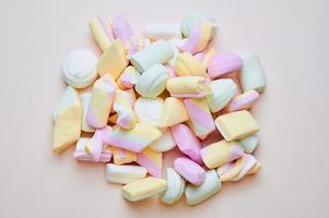 mixed pastel colored marshmallows on pink background photo