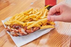 fingers taking french fries with Currywurst photo