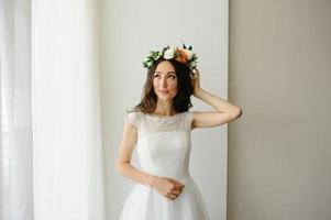 Beautiful bride tries on a wreath on her head. photo