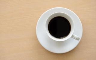 Top view of a cup of hot coffee on wooden table photo