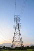 High voltage electricity pylon system, Electricity transmission power lines at sunset photo