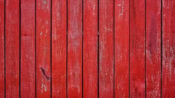 paredes de tablones de madera pintadas de color rojo con textura de grietas y fondo de textura rayada. foto