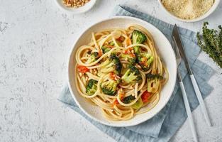 Spaghetti pasta with broccoli, bucatini with peppers, garlic, pine nuts. Food for vegans photo