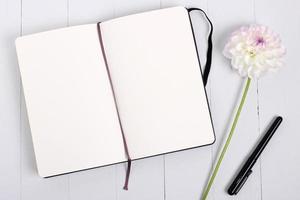 maqueta de cuaderno de bocetos con pluma y flor foto