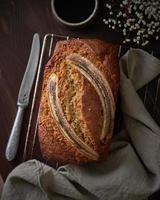 Banana bread. Cake with banana, traditional american cuisine. Whole loaf. Dark background photo