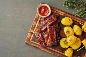 Spicy barbecue pork ribs, corn ears and crushed smashed potatoes. American Cuisine