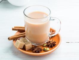 bebida india masala en el festival de holi. té con leche y especias en una taza de vidrio. foto