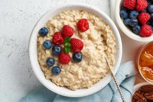 gachas de avena con arándanos, frambuesas, mermelada, vista superior, primer plano. desayuno con bayas foto