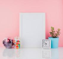 Blank white frame and plant cactus, sweet candy in jar on white photo