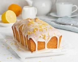 Lemon bread coated with sugar sweet. Cake with citrus, Whole loaf, side view, close up, vertical photo