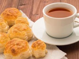 deliciosos rollos de exuberante hojaldre sin levadura en papel pergamino. desayuno con una taza de té y pasteles caseros por la mañana. foto