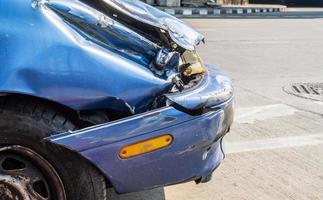 Front of blue car get damaged by accident on the road, damaged automobiles after collision in city photo