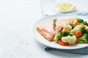 salmón y verduras al vapor, paleo, ceto, fodmap, dieta dash. comida mediterranea con pescado foto