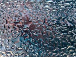 Abstract gray background with large and small convex drops of water on glass, condensation on window. Macro, close up. photo