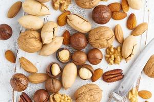 Mix of nuts - walnut, almonds, pecans, macadamia and knife for opening shell photo