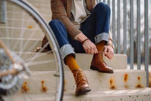 hombre de negocios poniéndose elegantes zapatos de cuero. preparándose para andar en bicicleta. foto