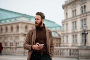 Young hipster businessman walking in city. Going to meeting. photo