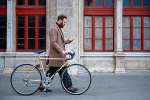 Businessman going to work on bike. Eco friendly transport in city photo