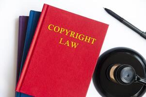 vista superior del libro de leyes de derechos de autor con mazo sobre fondo blanco foto