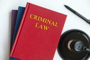 Top view of Criminal Law book with gavel on white background.