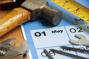 Working tools with May calendar on wooden table. Copy space concept. photo