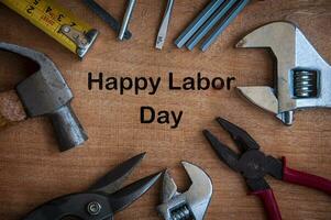 Text on wooden desk - Happy Labor Day with working tools background. photo