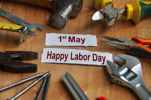 Happy labor day text on torn papers with working tools background. Labor day celebration concept. photo