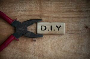 Text on wooden block - D.I.Y with working tool background.
