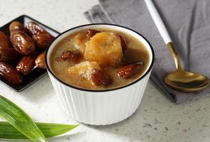 Kolak Pisang Kurma or Banana Dates Fruit Compote Made from Sliced Banana and Dates Fruit Stew in Coconut Milk and Brown Sugar. photo