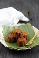 Bolu Sakura Steamed Caramel Cake, Made from Caramel with Cake Batter from Egg, Sugar, Flour, and Butter. Served on Wooden Plate with Banana Leaf. photo