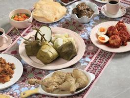 ketupat lebaran set, menú de paquete completo servido durante lebaran eid, en la mesa de mármol gris foto