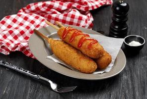Tasty Corn Dog in A Plate, Served with Ketchup and Mayonaise photo