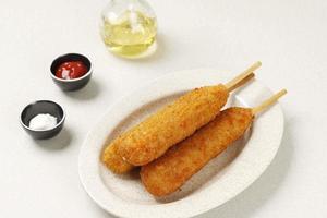 Organic CornDog on top of a walking stick with ketchup photo