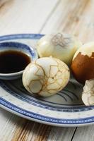 Chinese food boiled marble herbal tea egg on rustic wooden table top.