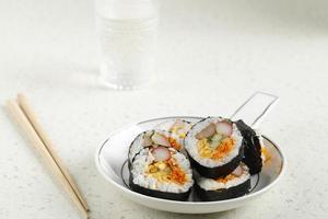 Korean Roll Gimbap Kimbob or Kimbap made from Steamed White Rice Bap and Various other Ingredients, Such As Kyuri, Carrot, Sausage, Crab Stick, or Kimchi and Wrapped with Seaweed Laver. photo