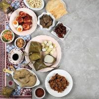 ketupat lebaran ied plato de menú, opor ayam, sambal goreng ati kentang, balado telur, dátiles, sambal y té. foto