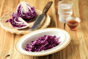 Fresh Slice Purple Cabbage on Ceramic Plate, Above Wooden Table. photo