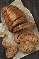 Traditional Spelled Sourdough Bread Cut into Slices on a Rustic Wooden Background photo