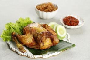 Ayam Goreng Utuh. Deep Fried Whole Chicken Served with Sambal Chilli Paste photo