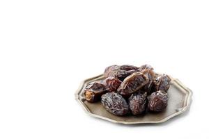 Medjool Date fruit on a White Background. Dates fruits on a rustic serving plate photo