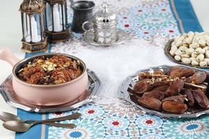 ramadan kareem y comida musulmana iftar, concepto de vacaciones. bandejas con frutos secos y frutos secos y farolillos con velas. idea de celebración foto