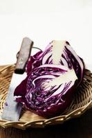 Sliced and a Whole of Purple Cabbage Vegetable on Top of Wooden Table photo